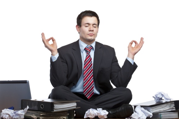 Gestresster, frustrierter Geschäftsmann meditiert im Büro auf Schreibtisch
